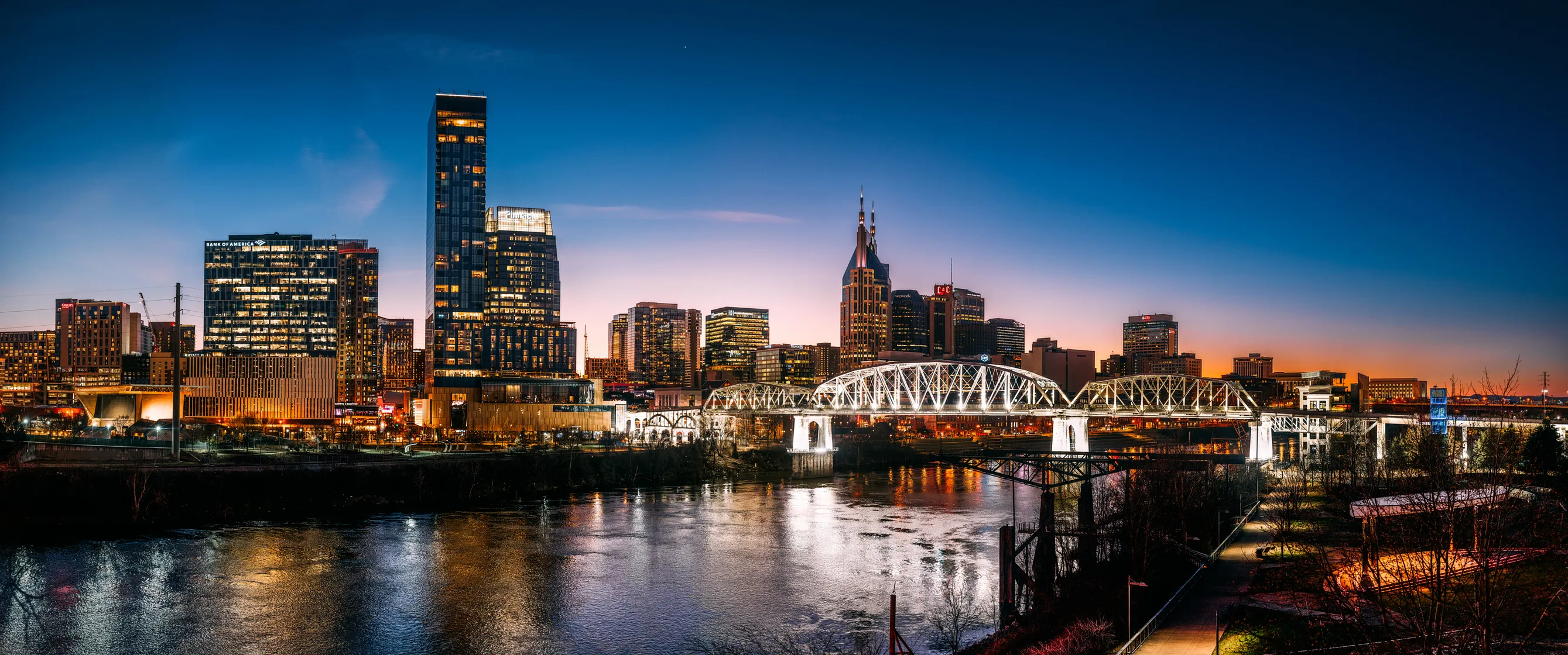 City skyline at dusk with river view.